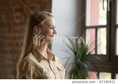 Smiling dreamy beautiful young woman looking in distance. 87180432