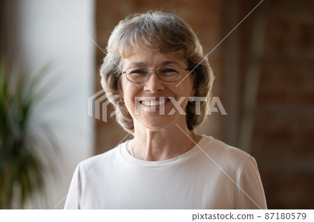 Head shot portrait of smiling middle aged woman. 87180579