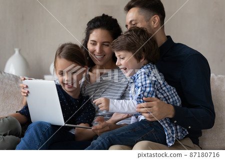 Happy joyful children and parents watching movie on laptop Happy joyful children and parents watching movie on laptop 87180716