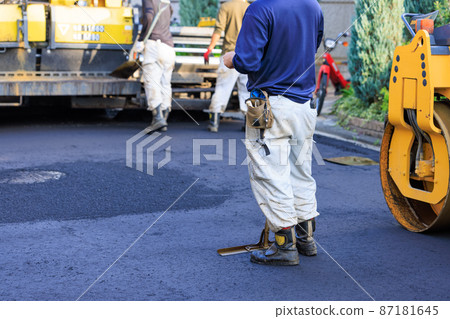 Workers paving asphalt on roads in residential areas 87181645