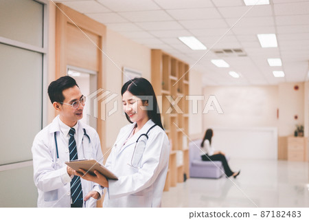 Asian doctor working and discuss for patient follow up treatment at hospital 87182483