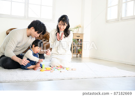 A young family playing with a baby in a family group with a beautiful mom who is pleased with the growth of a child Wide-angle lens A young family playing with a baby in a family group with a beautiful mom who is pleased with the growth of a child Wide-angle lens 87182669