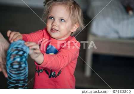 Portrait of adorable little blonde girl who is laughing. Cute blond little girl smiling while playing with mother Portrait of adorable little blonde girl who is laughing. Cute blond little girl smiling while playing with mother 87183200
