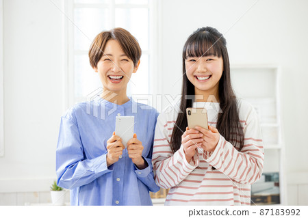 Mother with a smartphone as a parent and child Mother with a smartphone as a parent and child 87183992