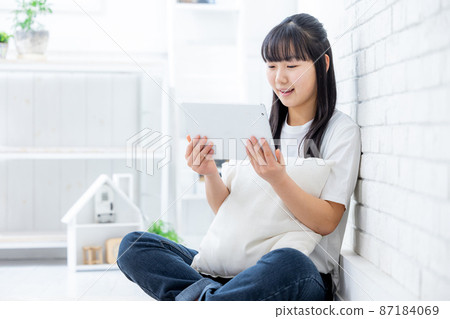 Girl watching videos on tablet 87184069