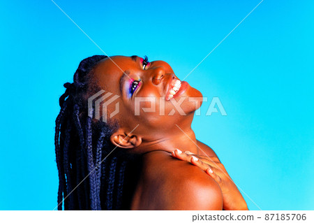 african american woman with gorgeus bright color make up feels proud and self confident in blue wall studio background 87185706