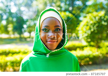 Beautiful modern student woman in hijab with make-up and piercing ring on the nose outdoor 87185707