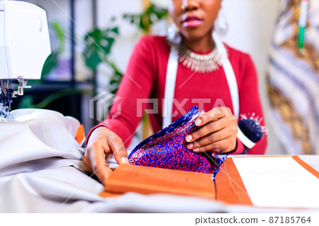 tanzanian woman with snake print turban over hear working in fashion house 87185764