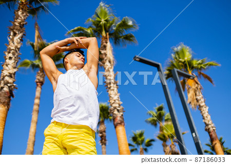 Strong brazilian man with a helathy body using spf cream in sunny day at beach Strong brazilian man with a helathy body using spf cream in sunny day at beach 87186033