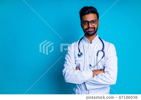 young latin hispanic medican man wear eye glasses with stethoscope in blue studio wall background young latin hispanic medican man wear eye glasses with stethoscope in blue studio wall background 87186036