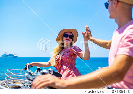 Couple on holiday with electric eco bicycles in sea vacations Couple on holiday with electric eco bicycles in sea vacations 87186468