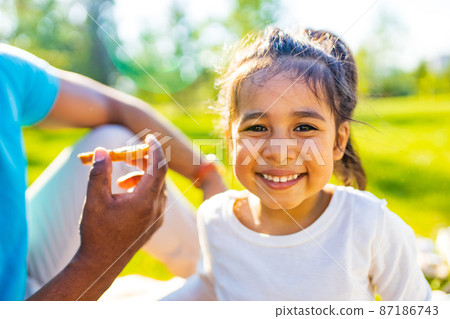Happy little girl enjoying picnic in nature Happy little girl enjoying picnic in nature 87186743