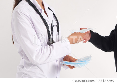 Doctor giving a patient protective face mask to protect from virus infection, coronavirus concept 87187869