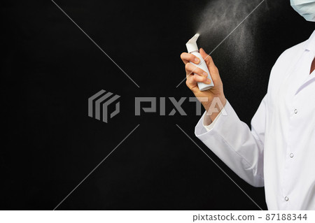 Cropped view of female hand using spray over black background 87188344