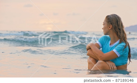 Woman sitting on water sea. Girl in turquoise swimsuit. Freedom paradise holiday vacation summer beach and seaside landscape concept Woman sitting on water sea. Girl in turquoise swimsuit. Freedom paradise holiday vacation summer beach and seaside landscape concept 87189146