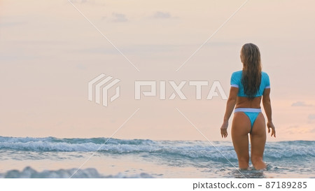 Woman standing on water sea. Girl stand in turquoise swimsuit. Freedom paradise holiday vacation summer beach, seaside landscape concept Woman standing on water sea. Girl stand in turquoise swimsuit. Freedom paradise holiday vacation summer beach, seaside landscape concept 87189285