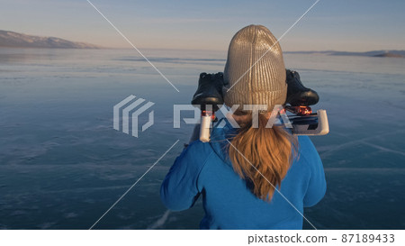 The child train on ice speed skating. Athlete puts on skates. The girl skates in the winter in sportswear, sport glasses. Outdoor slow motion. The child train on ice speed skating. Athlete puts on skates. The girl skates in the winter in sportswear, sport glasses. Outdoor slow motion. 87189433