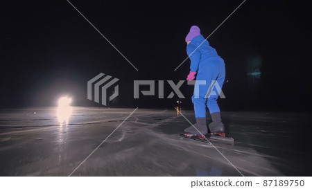 The child train on ice speed skating. The night skating. The girl skates in the winter in sportswear, sport glasses. Outdoor slow motion. The child train on ice speed skating. The night skating. The girl skates in the winter in sportswear, sport glasses. Outdoor slow motion. 87189750