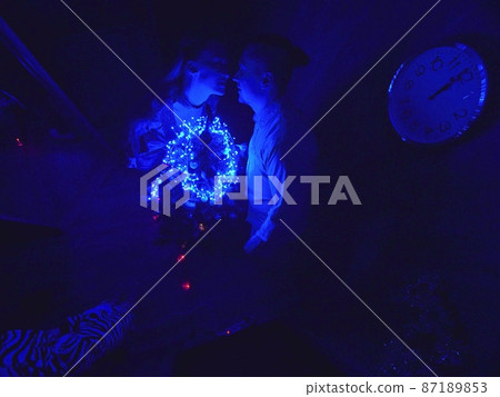 The family fast and fanny decorates the Christmas tree. Top view. Time on the clock is 23.45 on wall. Happy dad, mom, daughter are run around tree. 87189853