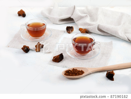 Healthy drink coffee from chaga mushroom in a glass cup on a white background. Top view. Copt spaes. 87190182