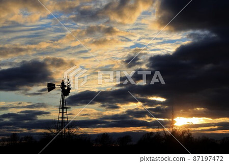 Kansas colorful Sunset with clouds and trees out in the country that's bright and colorful. Kansas colorful Sunset with clouds and trees out in the country that's bright and colorful. 87197472