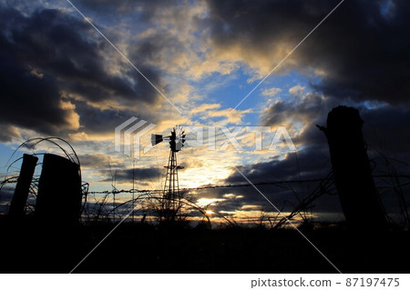 Kansas colorful Sunset with clouds and trees out in the country that's bright and colorful. 87197475