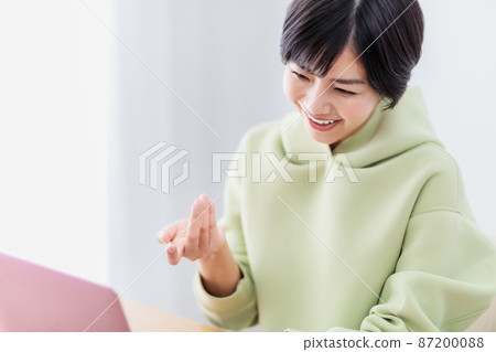 在客廳裡使用筆記本電腦的女士 87200088