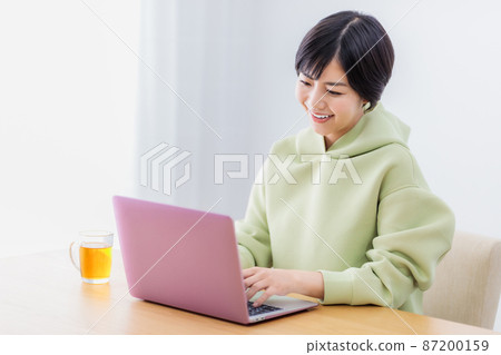 在客廳裡使用筆記本電腦的女士 在客廳裡使用筆記本電腦的女士 87200159