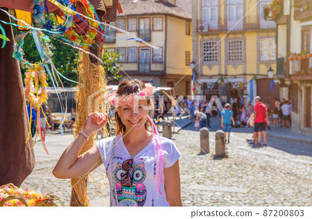 Young woman traveler with flower crown looking at camera Young woman traveler with flower crown looking at camera 87200803