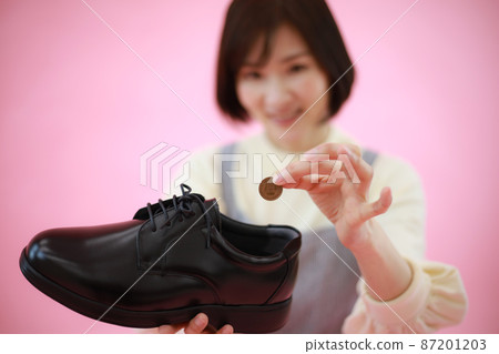 A woman who puts a 10-yen coin in a dress shoe A woman who puts a 10-yen coin in a dress shoe 87201203
