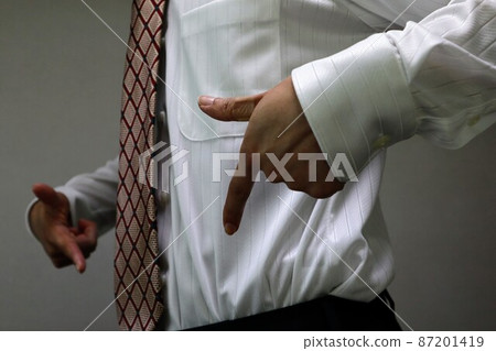 A businessman who succeeds in dieting and points to his stomach 87201419