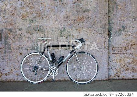 Warehouse iron door and black road bike 87203324