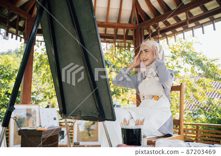 muslim female thinking while working in her project at studio 87203469