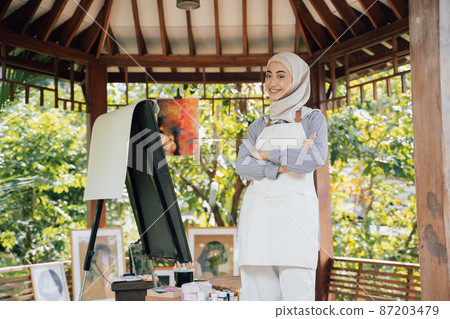 muslim female painter painting on canvas in her workshop 87203479