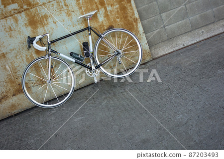 Rusted iron door and black road bike 87203493