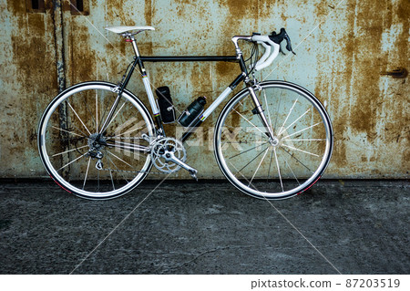 Rusted iron door and black road bike Rusted iron door and black road bike 87203519