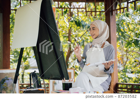 muslim Female artist painting on canvas at home studio muslim Female artist painting on canvas at home studio 87203582