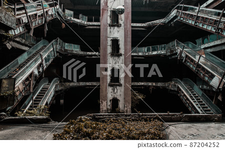 Damaged escalators in abandoned shopping mall building. 87204252