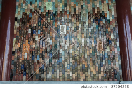 Chinese lettering teachings and Carved buddha images into a slab of colored tiles on temple wall of Fo Guang San Temple. 87204258