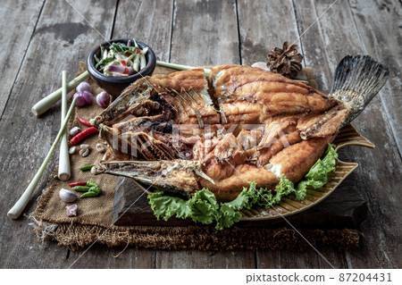 Deep fried Snapper with fish sauce on vintage wooden. Deep fried Snapper with fish sauce on vintage wooden. 87204431