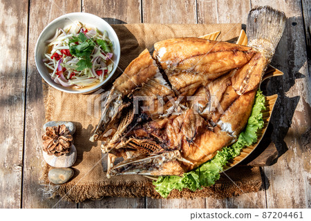Deep fried Snapper with fish sauce on vintage wooden. 87204461