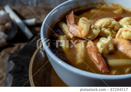 Close-up of Sour soup with lotus stem and shrimps (kaeng som koong with lotus stem), Thai food. Close-up of Sour soup with lotus stem and shrimps (kaeng som koong with lotus stem), Thai food. 87204517