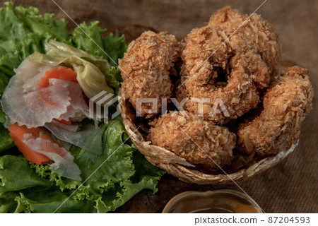 Deep-fried shrimp cakes (Tod Mun Goong) and vegetable with chili sauce on wooden background. 87204593