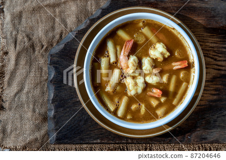 Sour soup with lotus stem and shrimps (kaeng som koong with lotus stem), Traditional Thai food. 87204646