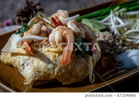 Close-up of Fried Thai Noodle with Shrimp Wrapped in Egg, That popular food for foreigner tourists. Close-up of Fried Thai Noodle with Shrimp Wrapped in Egg, That popular food for foreigner tourists. 87204666