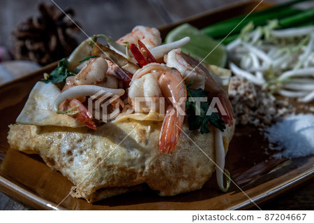 Close-up of Fried Thai Noodle with Shrimp Wrapped in Egg, That popular food for foreigner tourists. Close-up of Fried Thai Noodle with Shrimp Wrapped in Egg, That popular food for foreigner tourists. 87204667