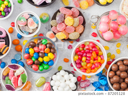 Pink lollipop candies in jar with various milk chocolate and jelly gums 87205128