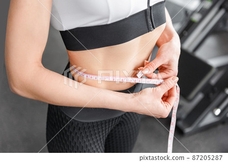 Perfect slim young body of the girl. Fitness or plastic surgery and aesthetic. 87205287