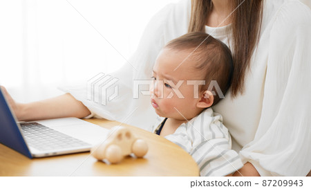 Mother showing her laptop to her baby Mother showing her laptop to her baby 87209943