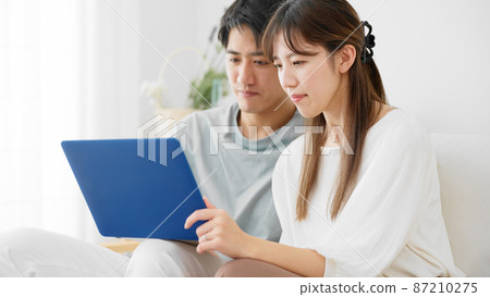 Young men and women using laptops Young men and women using laptops 87210275